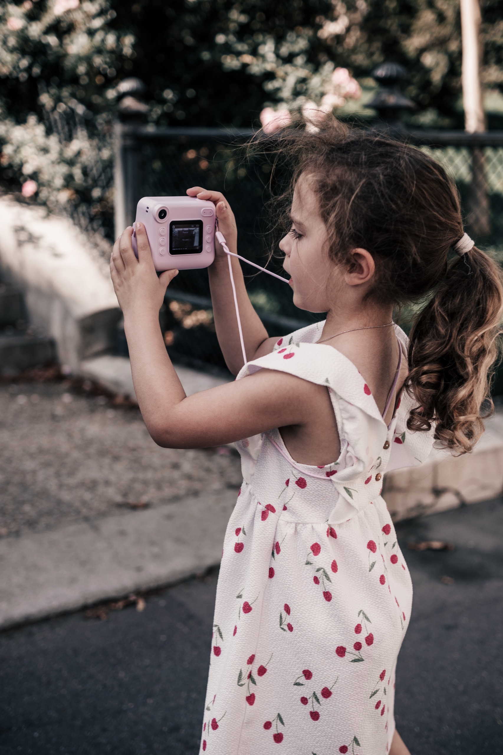 Kind fotografiert mit einer kleinen pinken Kamera