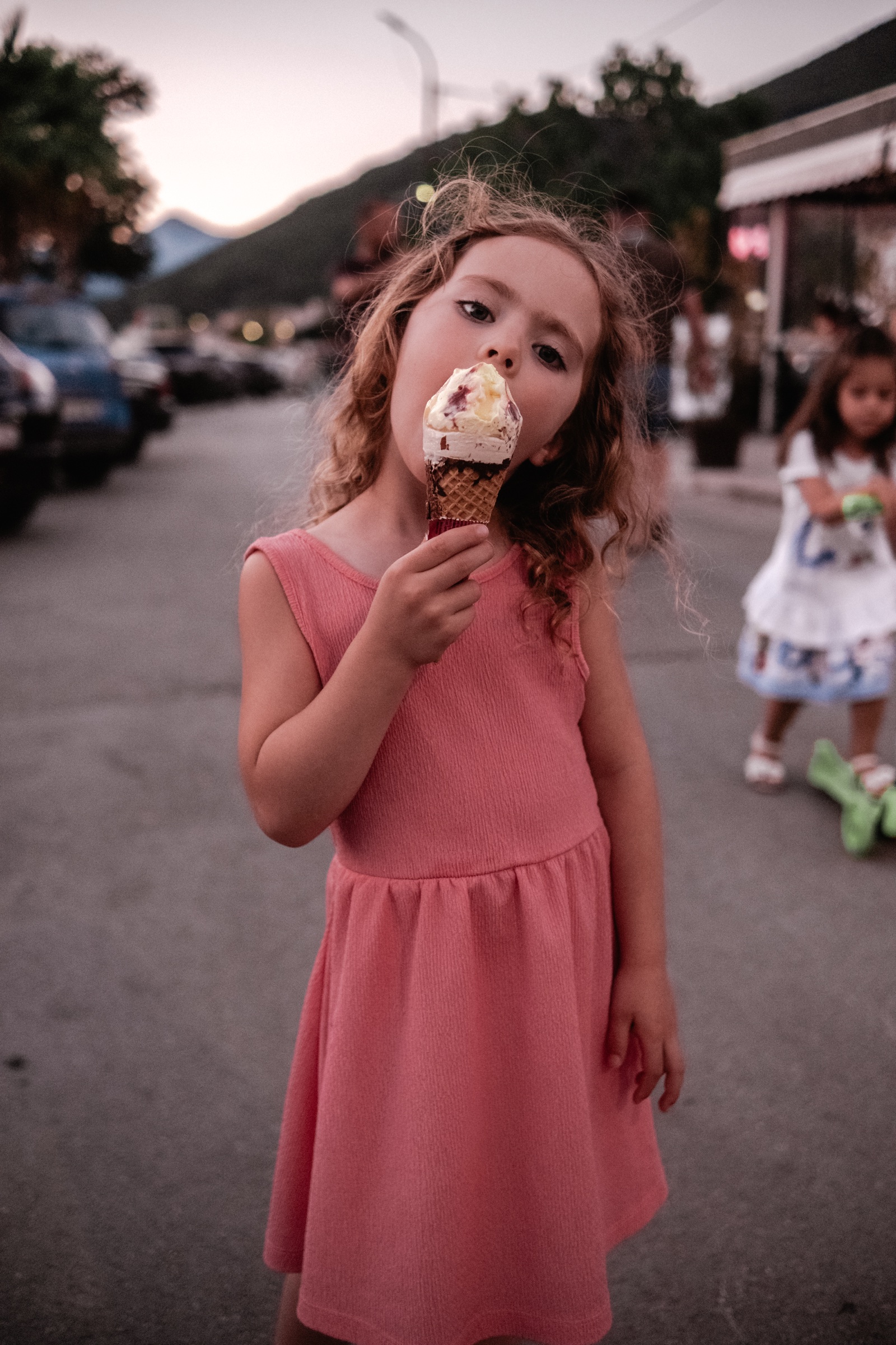 Kind genießt am Abend ein Eis auf der Straße